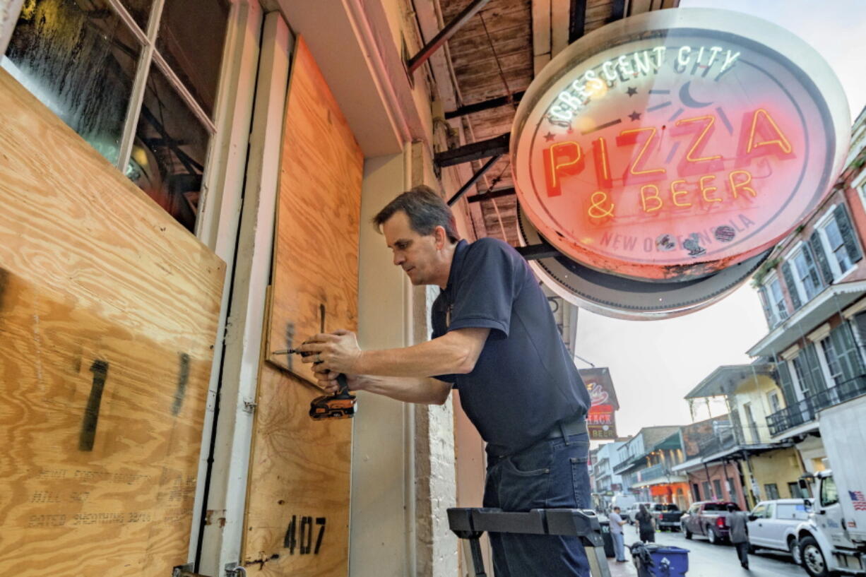 Michael Richard of Creole Cuisine Restaurant Concepts boards up Crescent City Pizza on Bourbon Street in the French Quarter before landfall of Hurricane Ida in New Orleans, Saturday, Aug. 28, 2021. Richard said the group is planning to board up and protect 34 restaurants owned by the company for the storm.