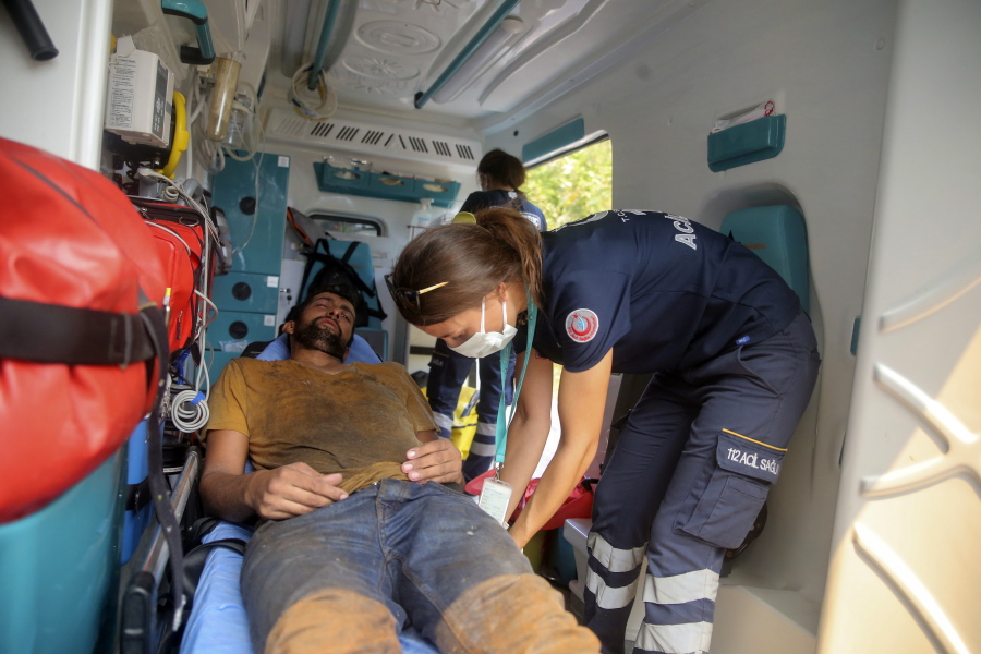 A nurse treats an exhausted Turkish volunteer as they fight wildfires in Turgut village, near tourist resort of Marmaris, Mugla, Turkey, Wednesday, Aug. 4, 2021.