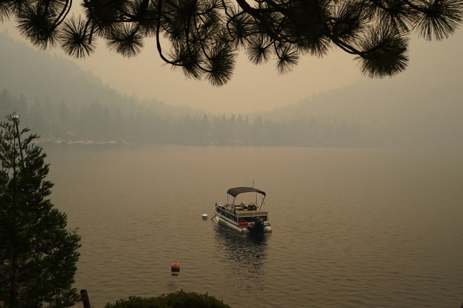Smoke from the Caldor Fire, shrouds Fallen Leaf Lake near South Lake Tahoe, Calif., Tuesday, Aug. 24, 2021. The massive wildfire, that is over a week old, has scorched more than 190 square miles, (492 square kilometers) and destroyed hundreds of homes since Aug. 14. It is now less than 20 miles from Lake Tahoe.