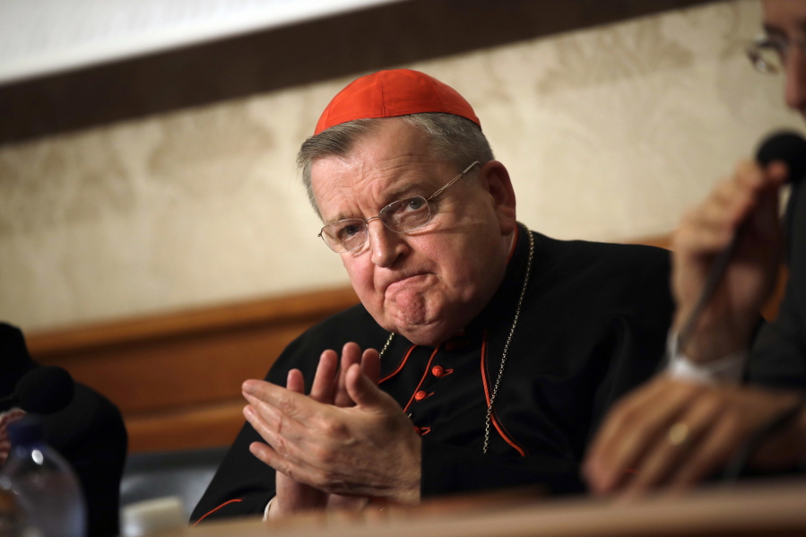 FILE - In this Sept. 6, 2018 file photo, Cardinal Raymond Burke applauds during a press conference at the Italian Senate, in Rome. Cardinal Burke, one of the Catholic Church's most outspoken conservatives and a vaccine skeptic, said he has COVID-19 and his staff said he is breathing through a ventilator. Burke tweeted Aug. 10 that he had caught the virus, was resting comfortably and was receiving excellent medical care.