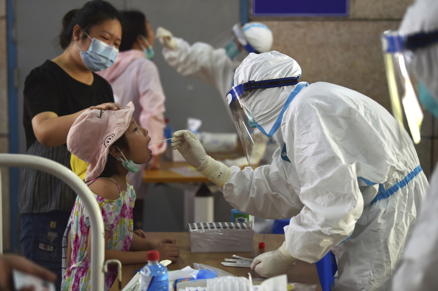 A nurse takes swab samples in the new rounds of Covid-19 testing in Nanjing in eastern China's Jiangsu province Monday, Aug. 2, 2021. China's worst coronavirus outbreak since the start of the pandemic a year and a half ago escalated Wednesday, Aug. 4, 2021 with dozens more cases around the country, the sealing-off of one city and the punishment of its local leaders.