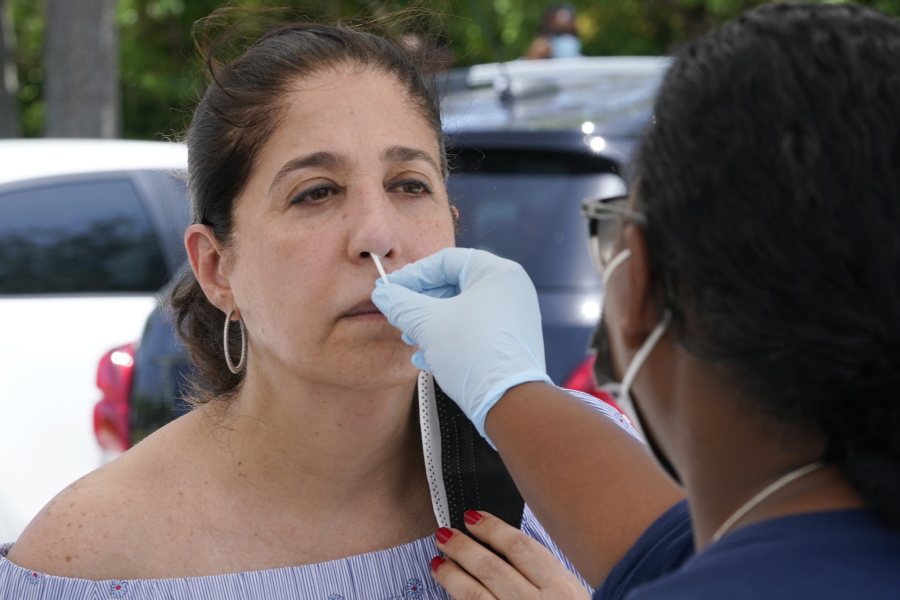 Raquel Heres gets a COVID-19 rapid test to be able to travel overseas, Saturday, July 31, 2021, in North Miami, Fla. Federal health officials say Florida has reported 21,683 new cases of COVID-19, the state's highest one-day total since the start of the pandemic. The state has become the new national epicenter for the virus, accounting for around a fifth of all new cases in the U.S. Florida Gov. Ron DeSantis has resisted mandatory mask mandates and vaccine.