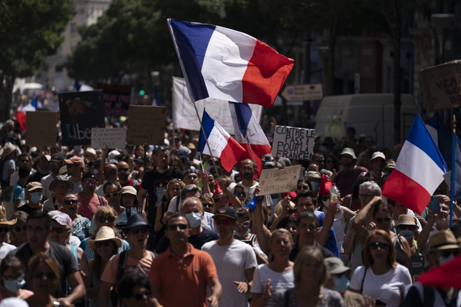 Protesters march during a demonstration in Marseille, southern France, Saturday, Aug. 14, 2021. Thousands of people, from families to far-right sympathizers, marched in dozens of cities across France for a fifth straight Saturday to denounce a COVID-19 health pass needed to access restaurant, long-distance trains and other venues.