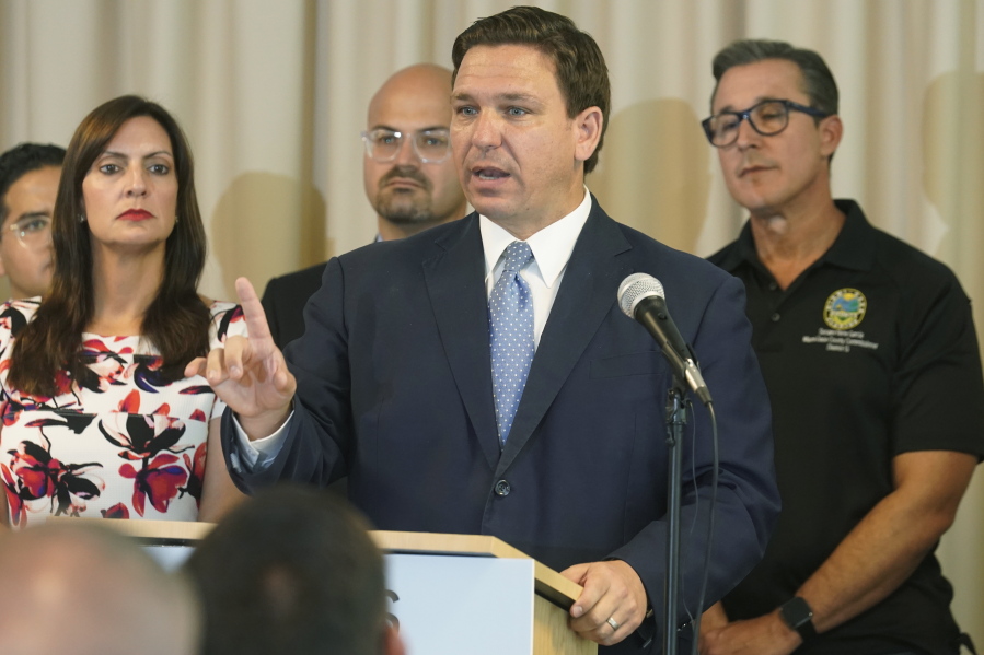 In this Aug. 10, 2021, photo, Florida Gov. Ron DeSantis answers questions related to school openings and the wearing of masks in Surfside, Fla. Top Republicans are battling school districts in their own states' urban, heavily Democratic areas over whether students should be required to mask up as they head back to school.