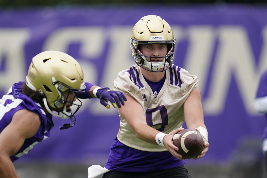 Washington Huskies quarterback Dylan Morris hands-off the ball during an NCAA college football team practice Friday, Aug. 6, 2021, in Seattle.