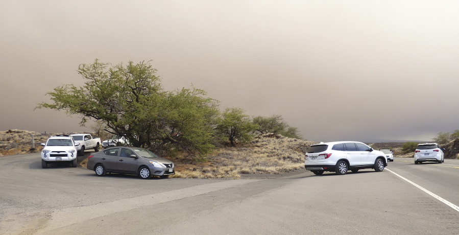 Vehicles turn onto Queen Kaahumanu Highway from an emergency access route opened after residents and visitors lodging in the Waikoloa Village area of Hawaii were ordered to evacuate as a wildfire threatened the South Kohala town Sunday, Aug. 1, 2021.