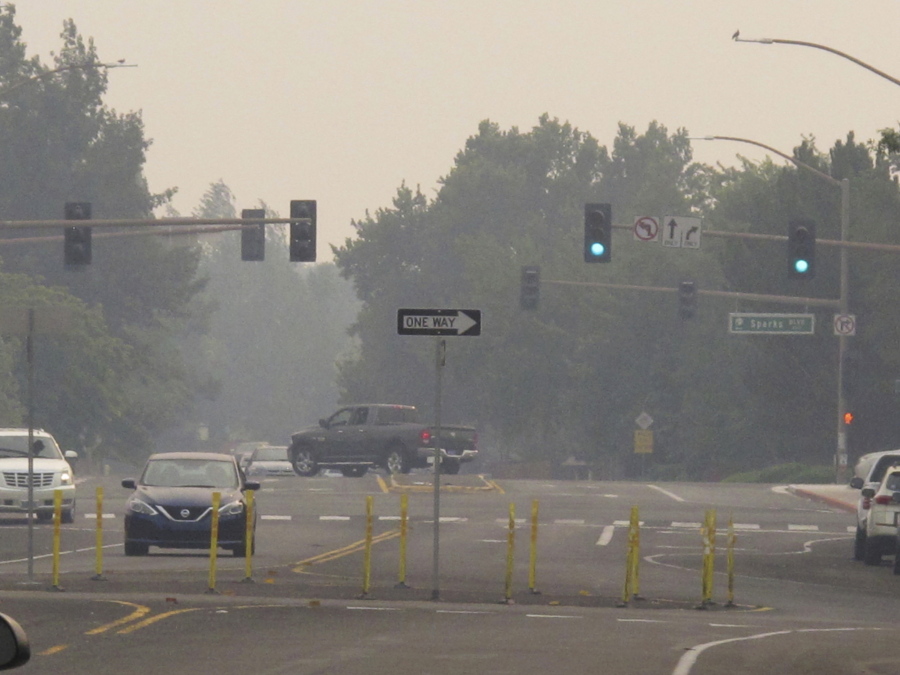 Smoke from wildfires in neighboring California blankets neighborhood streets in suburban Sparks, Nev., just east of Reno, Monday, Aug. 23, 2021. The Washoe County School District closed all schools including those in Reno, Sparks and parts of Lake Tahoe on Monday due to the hazardous air quality. The county health district urged the general public to "stay inside as much as possible" due to conditions expected to continue through Wednesday.