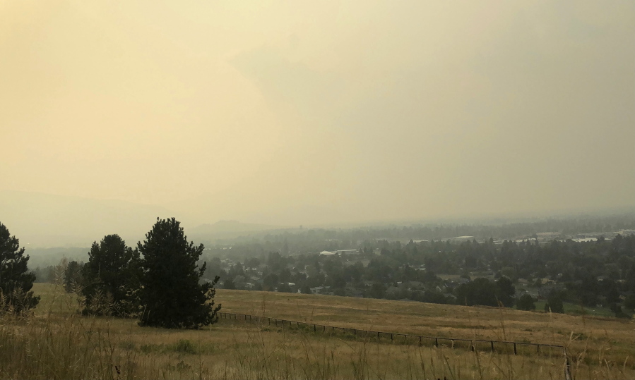 Smoke that has traveled from wildfires in Montana and the Western U.S., covers the Missoula Valley on Tuesday, Aug. 3, 2021, obscuring visibility and creating unhealthy air quality in Missoula, Mont.