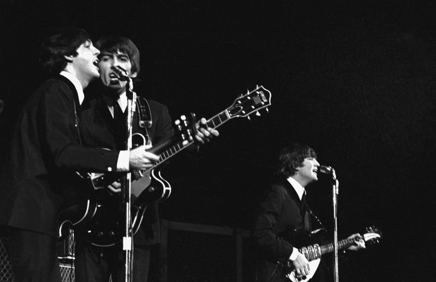 The Beatles' Paul McCartney and George Harrison in concert in America in 1964.