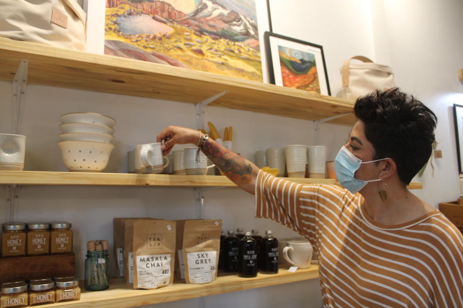 Lori Cano, owner of the new Poppy & Hawk retail shop in downtown Camas, straightens a stoneware coffee mug crafted by Hanselmann Pottery, a studio out of Corrales, N.M., on Aug. 26.