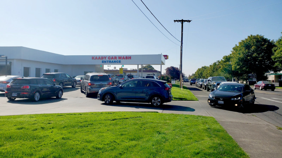 The line at Kaady Car Wash backed up on Mill Plain Boulevard on Wednesday morning after people awoke to their cars covered in ash from early-morning rainfall.