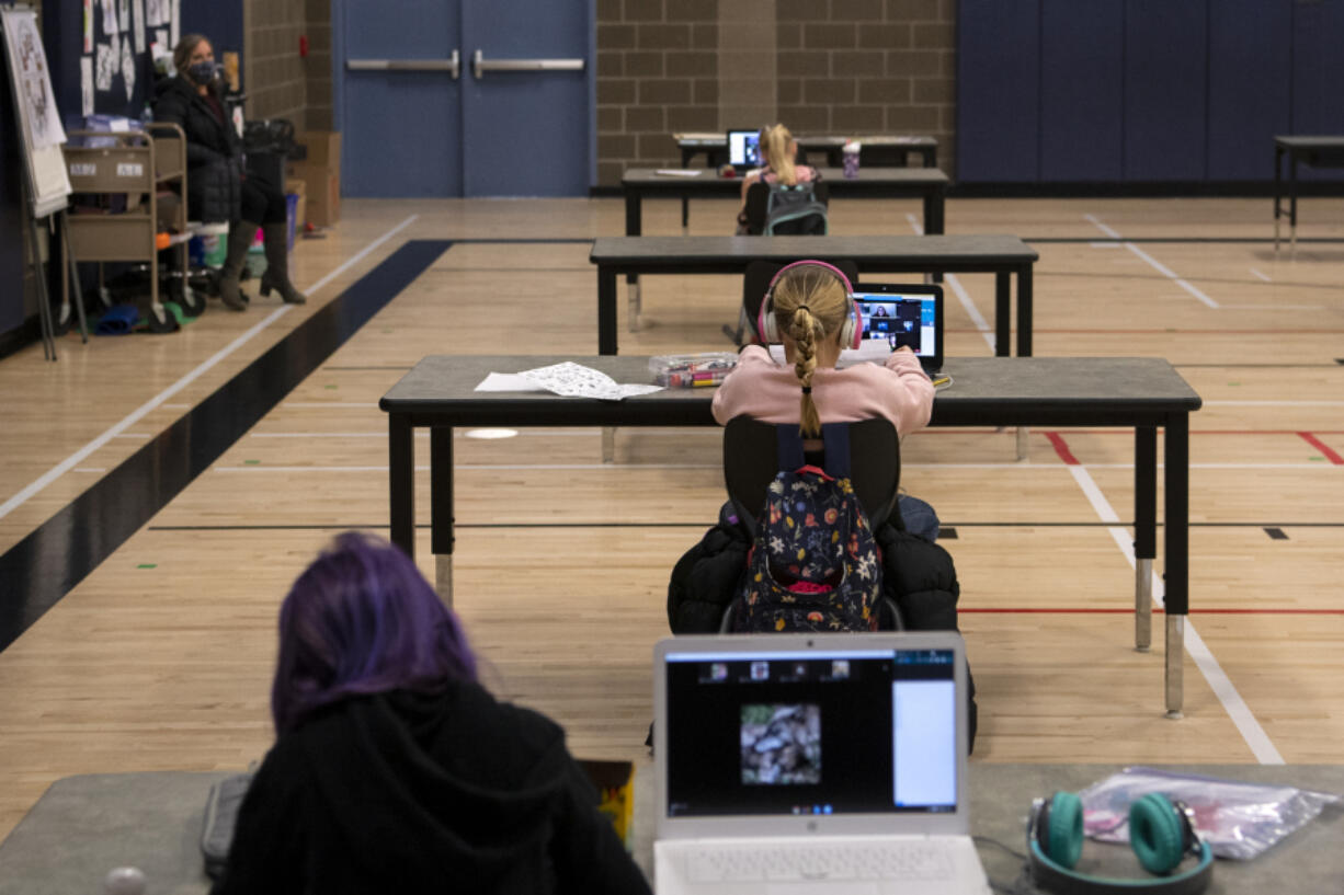 Students work in the "Internet Cafe" on Tuesday, Jan. 26, 2021, at Captain Strong Primary School in Battle Ground. Students are set up with Chromebooks in the gymnasium if they need internet to access remote learning.