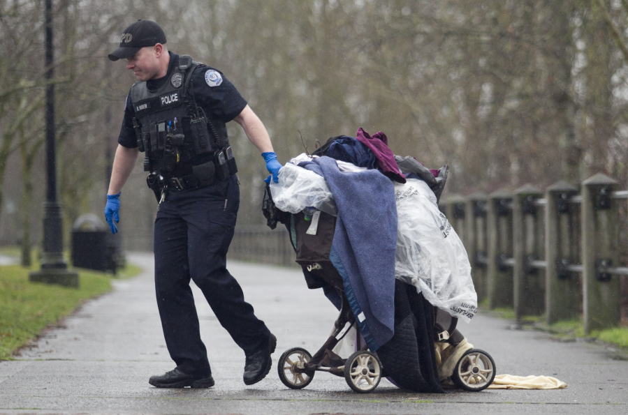 Officer Brian Ruder hauls away a load of debris left by houseless people along the Columbia River in 2015. The Vancouver City Council passed an ordinance Monday night allowing camping during the day for nighttime-working houseless people, and also to begin the process of selecting "supportive campsites" around the city.