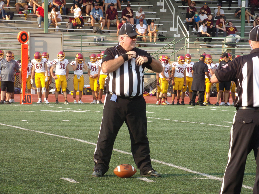 Chris Prothero of the Evergreen Football Officials Association stands over the ball during a timeout at the Union-O'Dea game on Sept. 3.