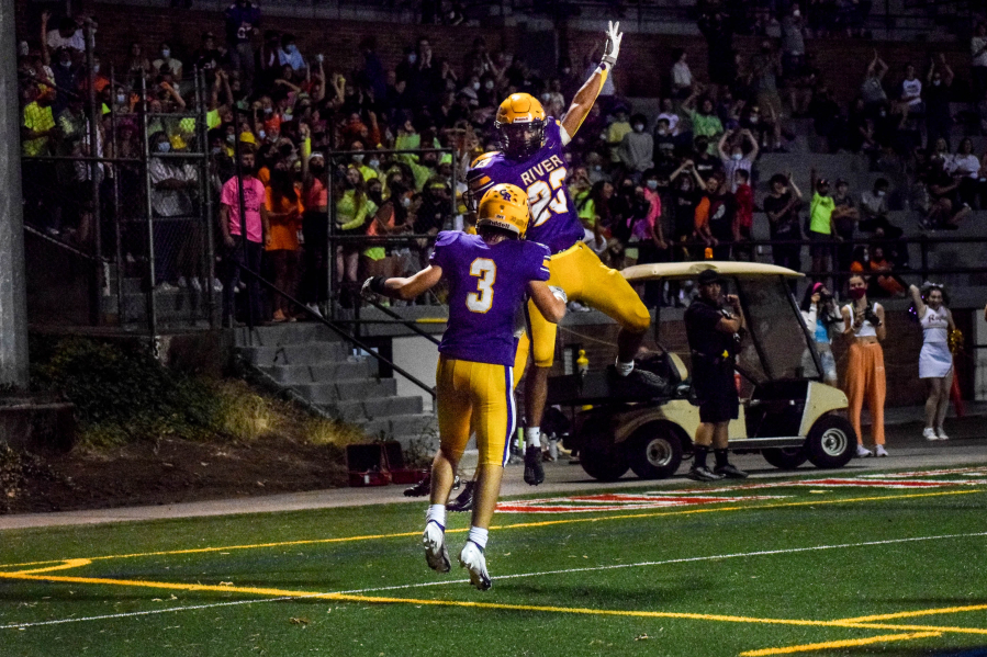 Columbia River's Victor Flores (23) and Thomas Blau (3) celebrate a Rapids touchdown run during River's 16-7 win over Woodland on Friday, Sept.