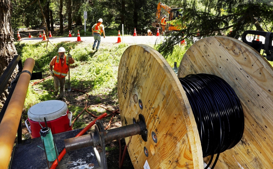 In this May 22, 2018 photo, a Whidbey Telecom crew prepares to thread fiber-optic cable under a road, which will deliver internet service to, in this case, a single home on Whidbey Island, in Freeland, Wash.