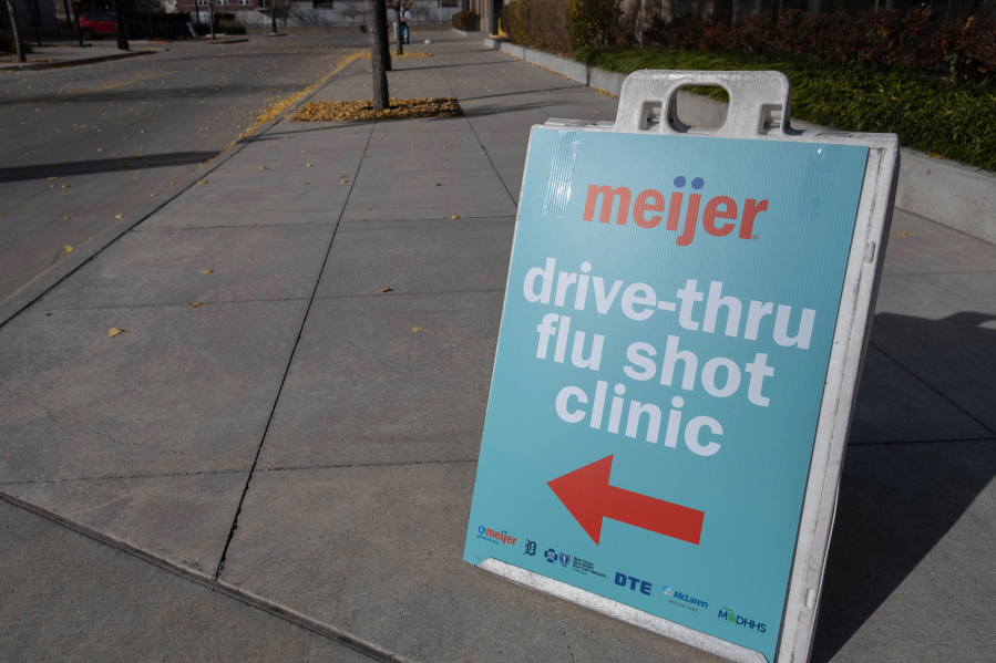 A sign directs traffic to a drive-thru flu shot station Nov. 10 at Comerica Park in Detroit, Mich. It's now flu season, and its symptoms resemble COVID-19's.