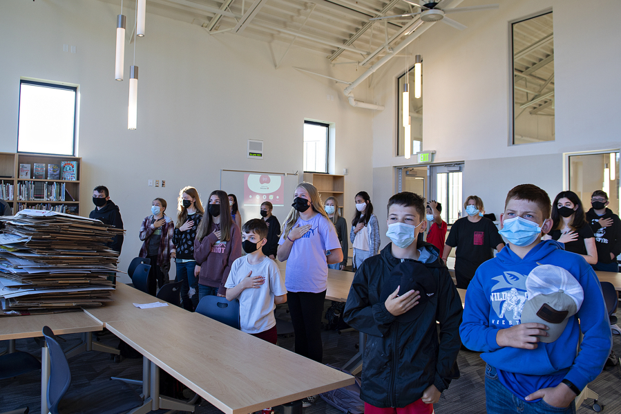 Seventh-grade students pause for the Pledge of Allegiance as they have their homeroom in the library, which is still being unpacked, at the new La Center Middle School. It's the first new school building in the district since the early 1990s.