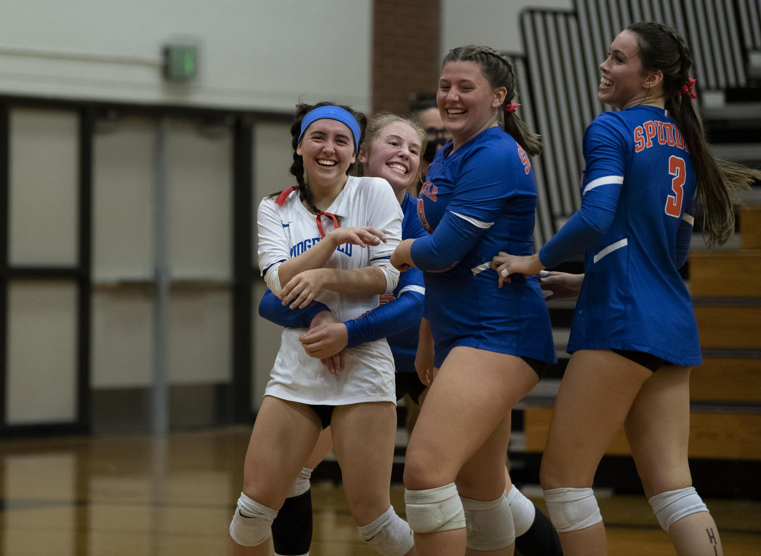 Ridgefield teammates swarm libero Emily Paul after her diving save kept the rally alive for a point the Spudders eventually won during a 2A Greater St. Helens League volleyball match on Tuesday, Sept. 21, 2021, at Columbia River High School. Ridgefield won 3-0.