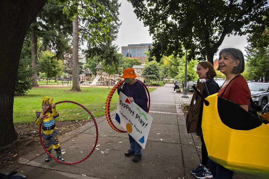 Ezra Little, 3, of Portland, from left, checks out a grown-up sized hula hoop while greeting Columbia Play Project performers Mary Sisson, Maureen Montague and Jeanne Bennett for a Give More 24! fundraiser Thursday morning at Esther Short Park in downtown Vancouver. The nonprofit set its fundraising goal at $10,000 and had received nearly $8,000 by late afternoon.