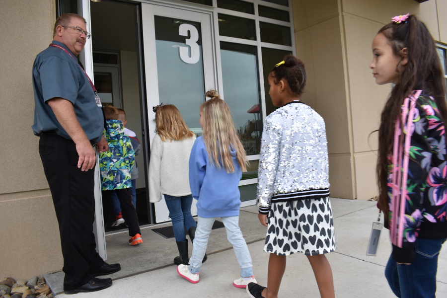 Principal Brad Foss holds the door for students returning from recess at Fox Hills Elementary School, Aug. 26, 2021, in Watford City, N.D., part of McKenzie County, the fastest-growing county in the U.S. School enrollment tripled over the past decade and is expected to double again by 2030, as McKenzie County became the fastest growing county in the U.S.