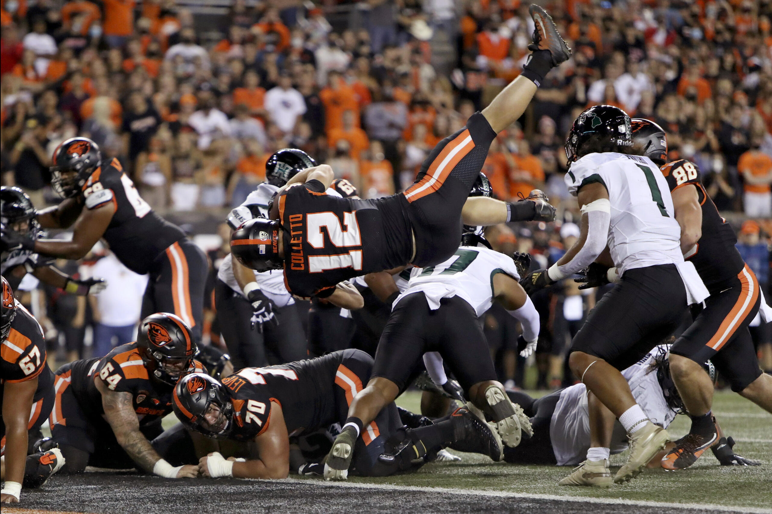 Oregon State inside linebacker Jack Colletto (12) flies backwards into the end zone for a touchdown during the first half of an NCAA college football game against Hawaii Saturday, Sept. 11, 2021, in Corvallis, Ore.