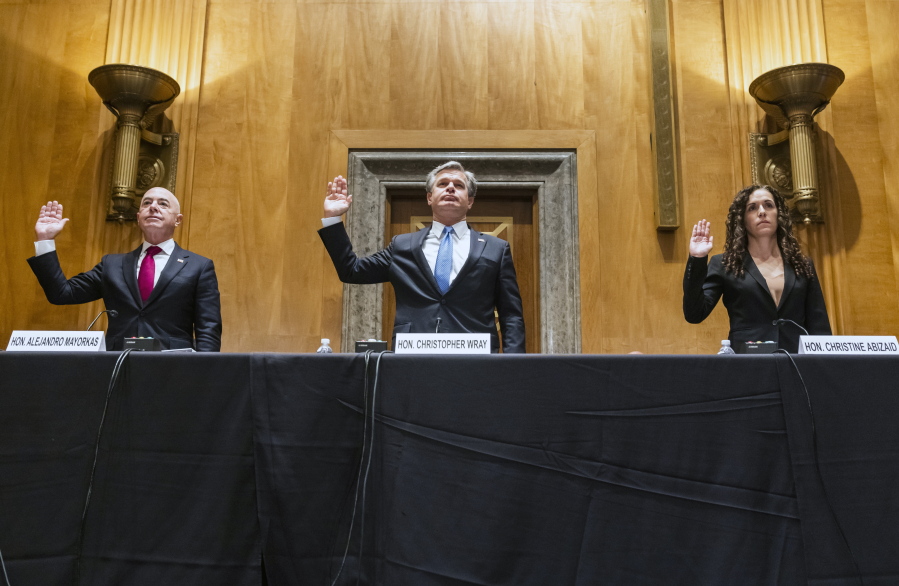 Secretary of Homeland Security Alejandro Mayorkas, left, FBI Director Christopher Wray, center, and Director of the National Counterterrorism Center Christine Abizaid, are sworn-in prior to testifying before a Senate Homeland Security and Governmental Affairs Committee hearing to discuss security threats 20 years after the 9/11 terrorist attacks, Tuesday, Sept. 21, 2021 on Capitol Hill in Washington.