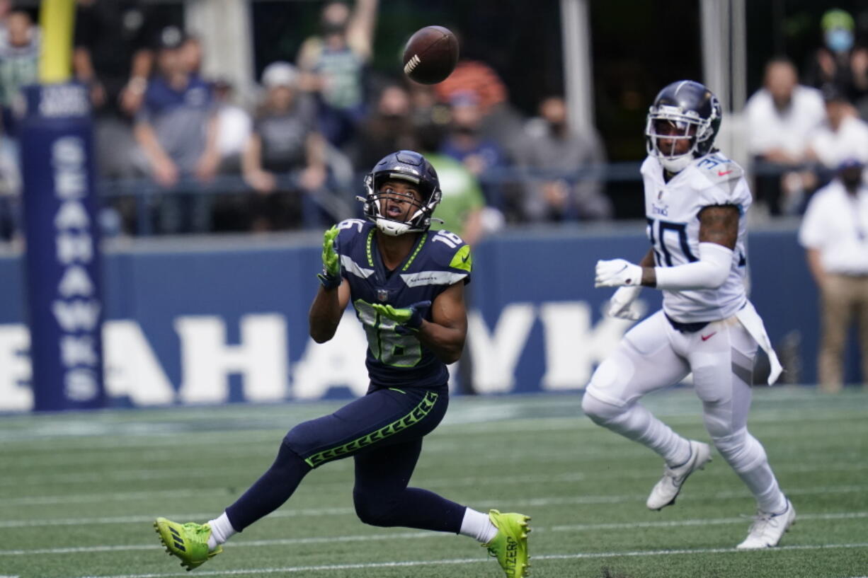 Seattle Seahawks wide receiver Tyler Lockett (16) catches a pass before running for a touchdown in from of Tennessee Titans strong safety Bradley McDougald, right, during the first half of an NFL football game, Sunday, Sept. 19, 2021, in Seattle.