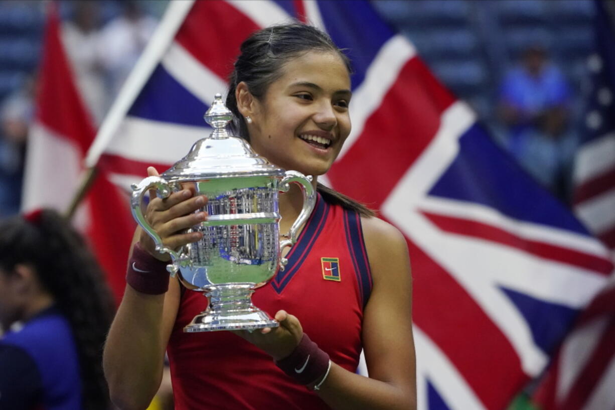 Emma Raducanu, of Britain, holds up the US Open championship trophy after defeating Leylah Fernandez, of Canada, during the women's singles final of the US Open tennis championships, Saturday, Sept. 11, 2021, in New York.