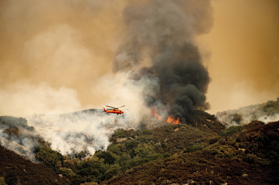 A helicopter prepares to drop water on the KNP Complex Fire on Wednesday in Sequoia National Park, Calif.