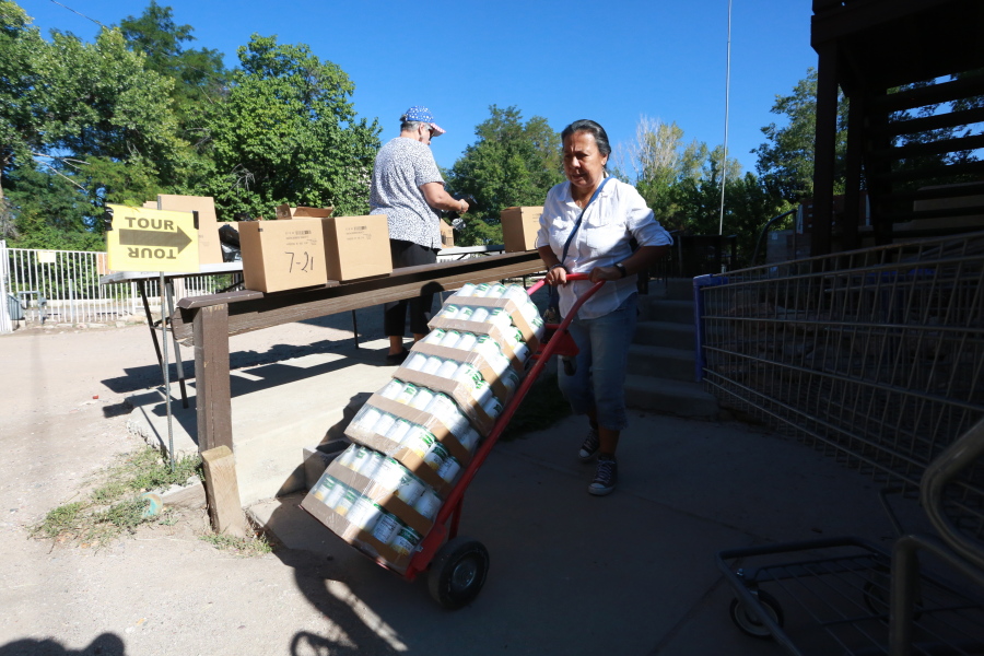 Barrios Unidos president Lupe Salazar pushes a dolly filled with canned food ahead of a food drive on Thursday, Sept. 23, 2021, in Chimay?, New Mexico.