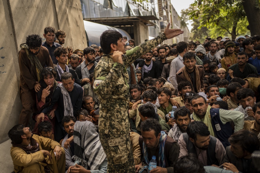 Afghans wait in front of a bank as they try to withdraw money in Kabul, Afghanistan, Sunday, Sept. 12, 2021.