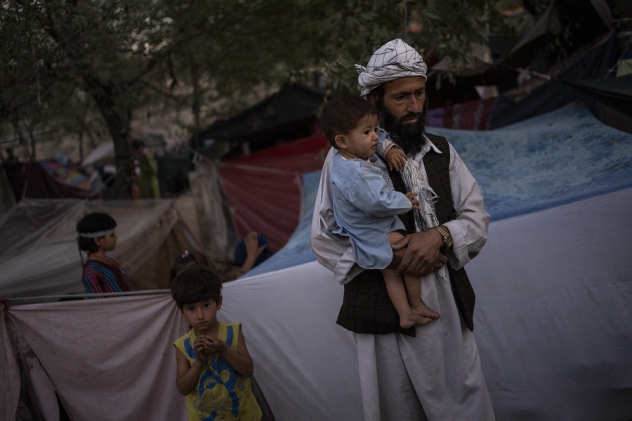 A displaced Afghan family waits for food donations at a camp for internally displaced persons in Kabul, Afghanistan, Monday, Sept. 13, 2021.