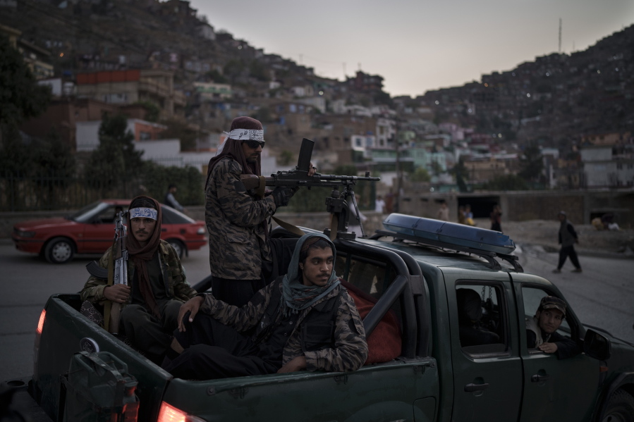 Taliban fighters sit on the back of a pickup truck as they stop on a hillside in Kabul, Afghanistan, Sunday, Sept. 19, 2021.