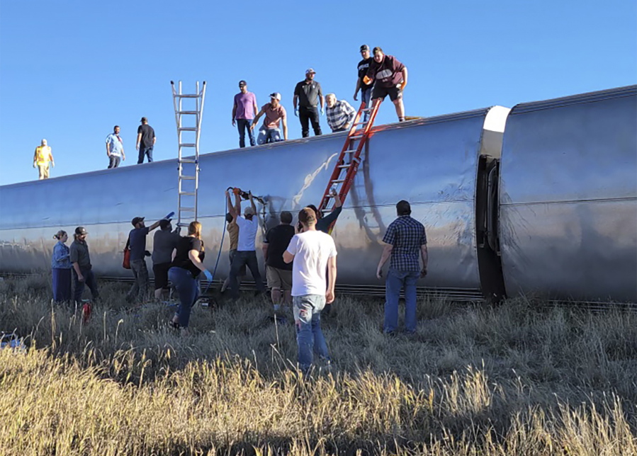 In this photo provided by Kimberly Fossen people work at the scene of an Amtrak train derailment on Saturday, Sept. 25, 2021, in north-central Montana. Multiple people were injured when the train that runs between Seattle and Chicago derailed Saturday, the train agency said.