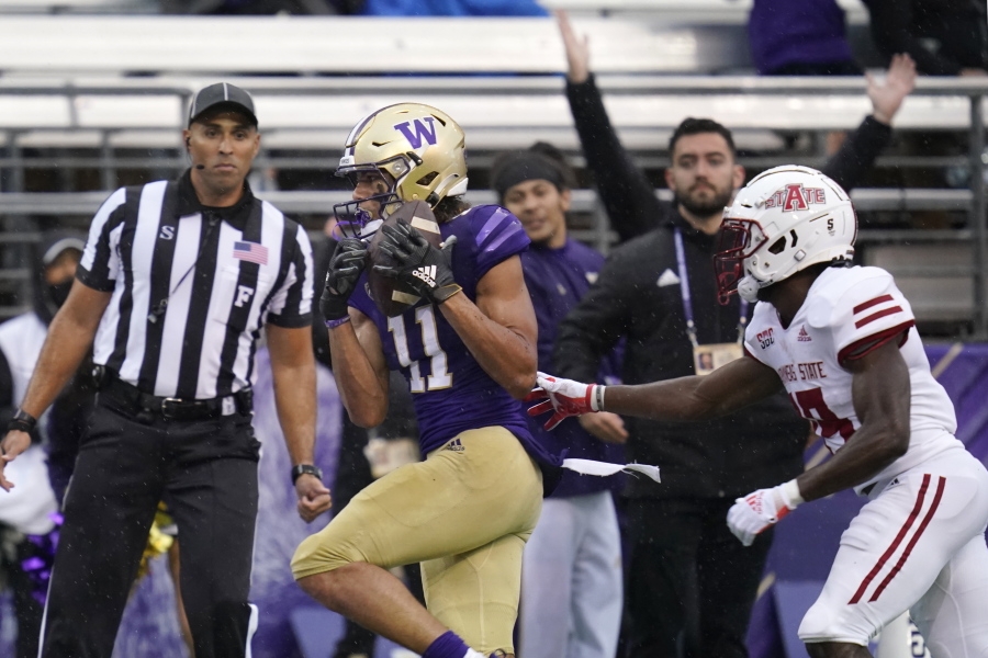 Washington's Jalen McMillan (11) scores on a 33-yard pass reception as Arkansas State's Denzel Blackwell defends in the first half of an NCAA college football game, Saturday, Sept. 18, 2021, in Seattle.