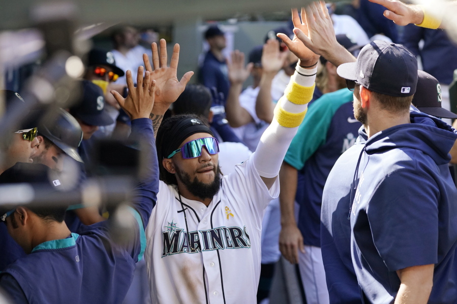 Seattle Mariners' J.P. Crawford is congratulated by teammates after scoring against the Houston Astros during the sixth inning of a baseball game Wednesday, Sept. 1, 2021, in Seattle.
