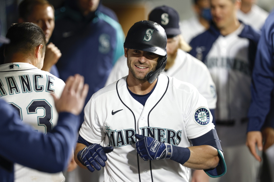 Seattle Mariners' Mitch Haniger celebrates in the dugout after hitting a solo home run in the seventh inning of a baseball game against the Oakland Athletics Tuesday, Sept. 28, 2021, in Seattle.