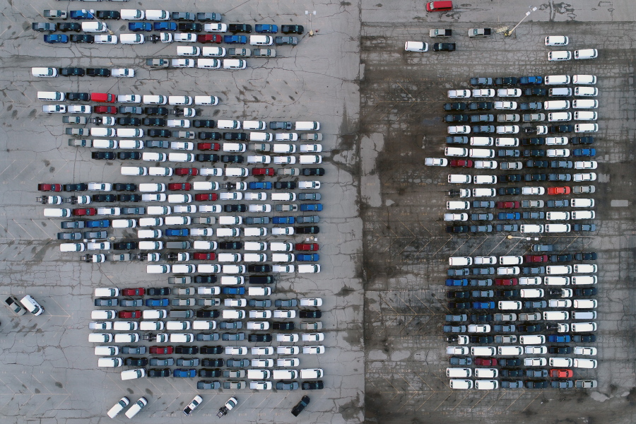 FILE - In this March 24, 2021 file photo, mid-sized pickup trucks and full-size vans are seen in a parking lot outside a General Motors assembly plant where they are produced in Wentzville, Mo. The global shortage of computer chips is getting worse, forcing automakers to temporarily close factories including those that build popular pickup trucks. General Motors announced Thursday, Sept, 2, 2021 that it would pause production at seven North American plants during the next two weeks, including two that make the company's top-selling Chevrolet Silverado pickup.