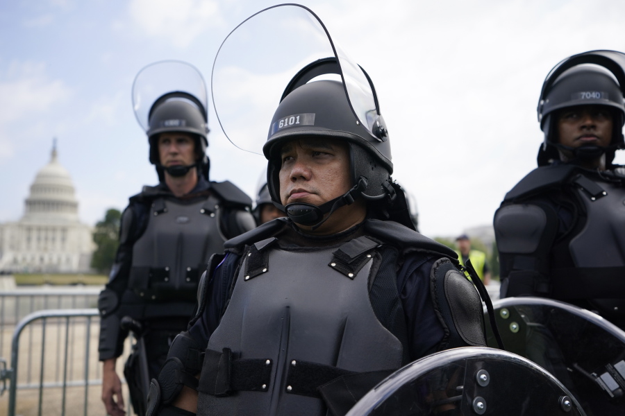 Police in riot gear patrol as people attend a rally near the U.S. Capitol in Washington, Saturday, Sept. 18, 2021. The rally was planned by allies of former President Donald Trump and aimed at supporting the so-called "political prisoners" of the Jan. 6 insurrection at the U.S. Capitol.