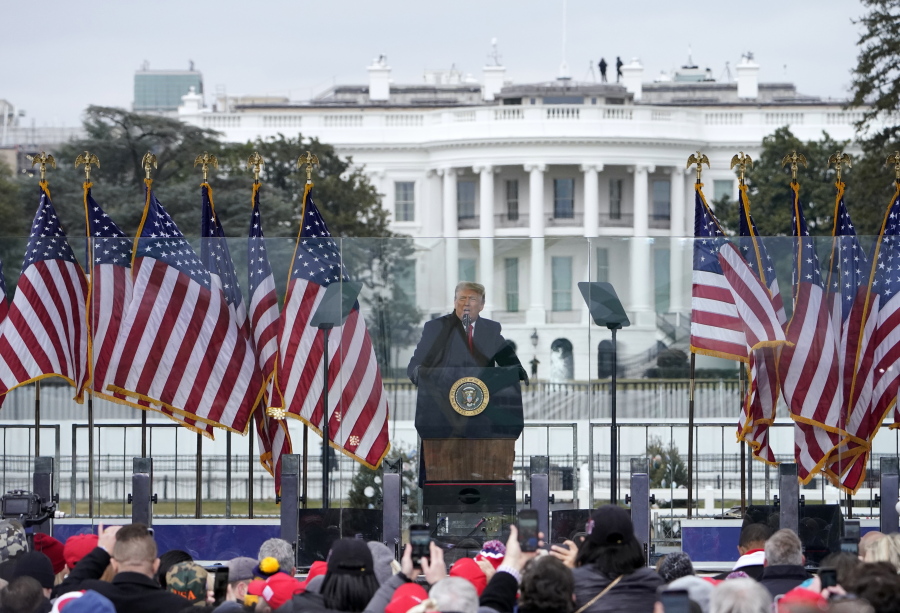 FILE - In this Jan. 6, 2021, file photo with the White House in the background, President Donald Trump speaks at a rally in Washington. The Biden administration will have a big say in whether the government releases information to Congress on the actions of former president Donald Trump and his aides on Jan. 6. But there could be a lengthy court battle before any details come out.