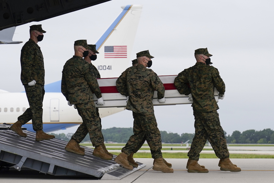 President Joe Biden watches as a carry team moves a transfer case containing the remains of Marine Corps Lance Cpl. Jared M. Schmitz, 20, of St. Charles, Mo., during a casualty return Sunday, Aug. 29, 2021, at Dover Air Force Base, Del. According to the Department of Defense, Schmitz a died in an attack at Afghanistan's Kabul airport, along with 12 other U.S. service members.