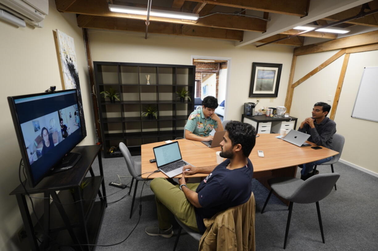 RunX CEO Ankur Dahiya, center, takes part in a video meeting with employees JD Palomino, top left, and Nitin Aggarwal, right, at a rented office in San Francisco, Friday, Aug. 27, 2021. Technology companies like RunX that led the charge into remote work early as the pandemic unfurled, are confronting a new challenge as it winds down: how, when and even whether they should bring their long-isolated employees back to offices that have been designed for teamwork.