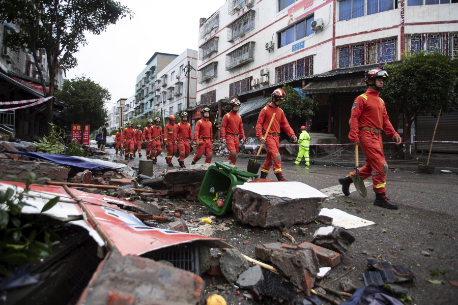 In this photo released by Xinhua News Agency, rescue workers walk near debris in the aftermath of an earthquake in Fuji Township of Luxian County in southwestern China's Sichuan Province, on Thursday, Sept. 16, 2021.An earthquake collapsed homes, killed some and injured others Thursday in southwest China's Sichuan province, state media reported.