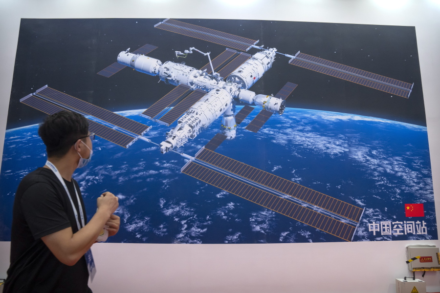 A visitor looks at a mural showing an artist's rendering of China's space station at the World Robot Conference in Beijing, Saturday, Sept. 11, 2021. Three Chinese astronauts have departed from the country's orbiting space station in preparation for returning to Earth after 90 days in orbit, the national space agency reported Thursday, Sept. 16, 2021.