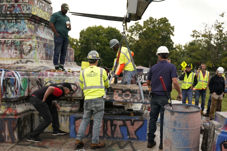 Crews move a section of the base as they attempt to locate a time capsule said to be buried in the base of the statue of on Monument Avenue in Richmond, Va., Thursday, Sept. 9, 2021. The statue was removed from the pedestal on Wednesday.