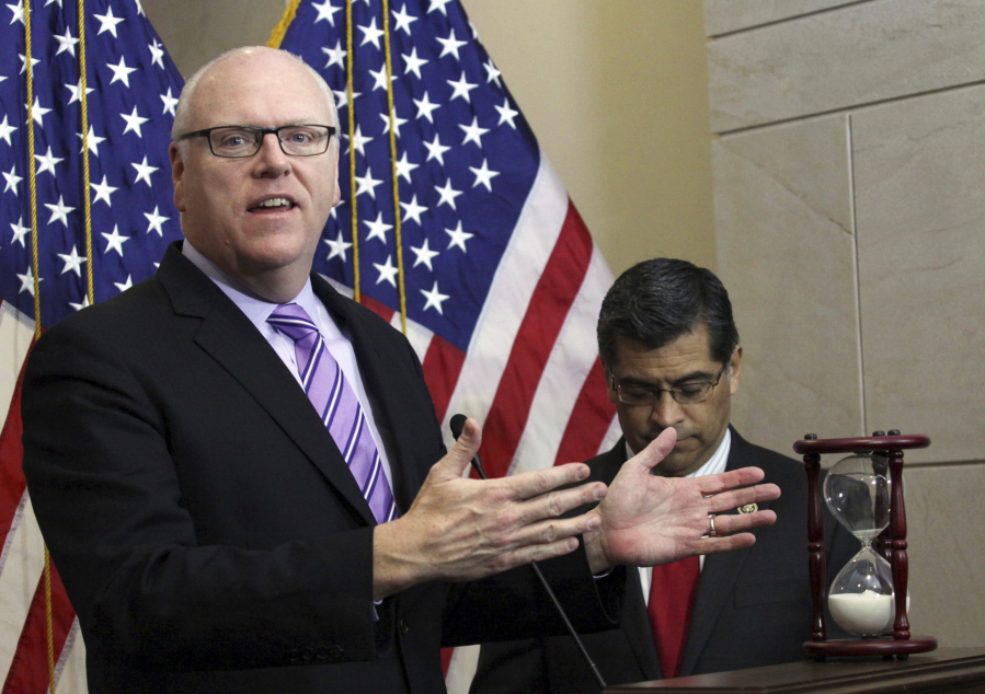 FILE - In this Feb. 25, 2015, file photo Rep. Joe Crowley, D-N.Y. left, accompanied by Rep. Xavier Becerra, D-Calif., gestures during news conference on Capitol Hill in Washington. Opposition from some leading moderate Democrats over a $3.5 trillion budget proposal championed by the party's most-liberal, progressive wing has left the party grappling with deeper ideological questions. "This is critically important for Democrats and for their message in next year's election," said former New York congressman Joe Crowley, a veteran Democrat who was upset in the 2018 primary by progressive star, Rep. Alexandria Ocasio-Cortez.