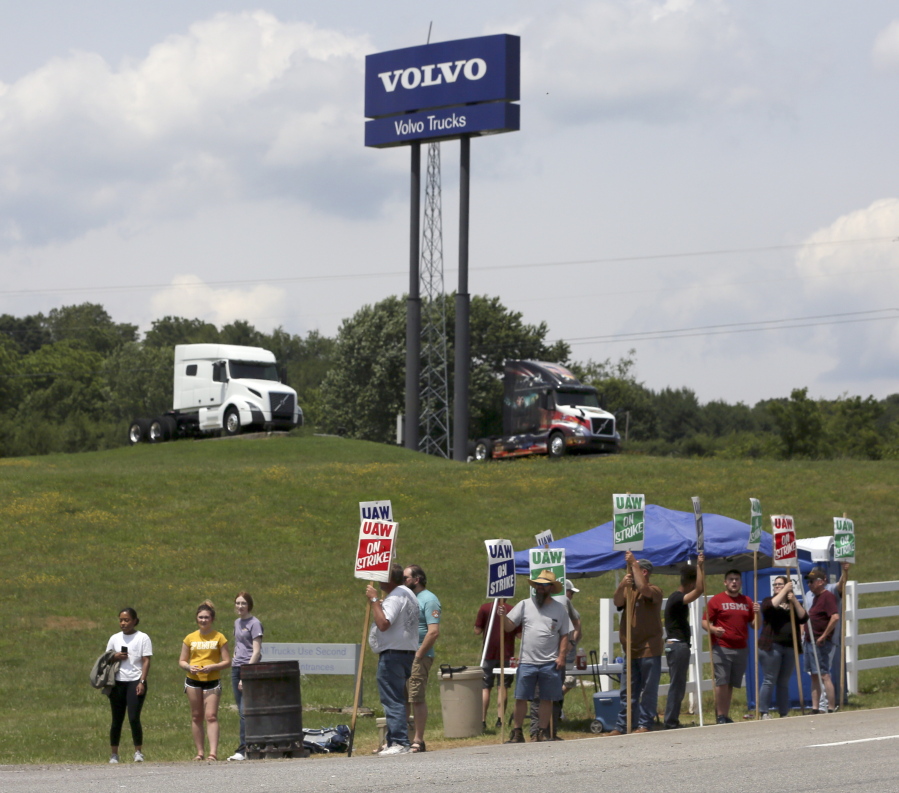 FILE - In this June 18, 2021 file photo, UAW Members strike outside the Volvo Trucks North America plant in Dublin, Va.    With Help Wanted signs at factories and businesses spreading across the nation, in manufacturing and in service industries, union workers like those at the Volvo site are seizing the opportunity to try to recover some of the bargaining power -- and financial security -- they feel they lost in recent decades as unions shrank in size and influence.