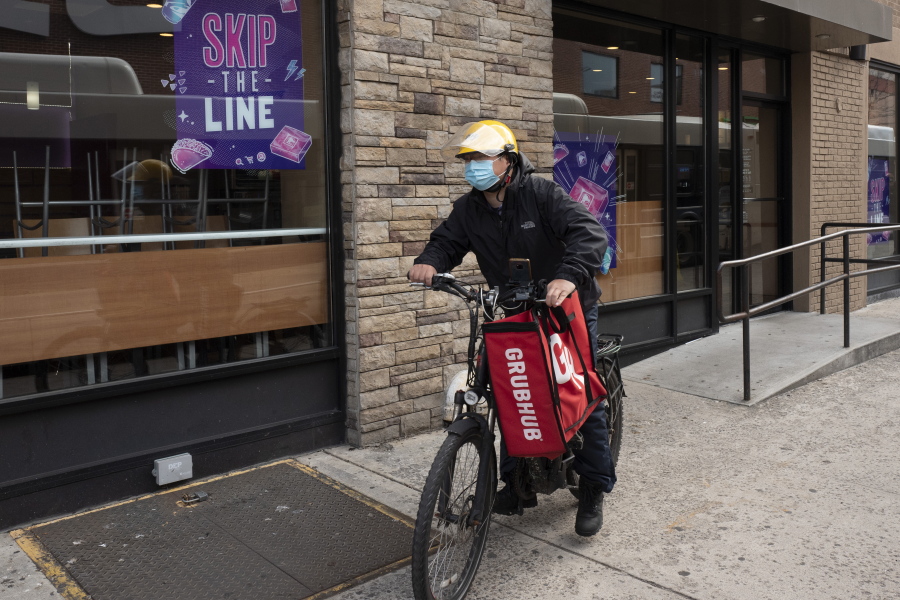 FILE - In this April 21, 2021 file photo, a delivery man bikes with a food bag from Grubhub in New York.  The three biggest food delivery companies, DoorDash, Grubhub and Uber Eats, are suing the City of New York, Friday, Sept.