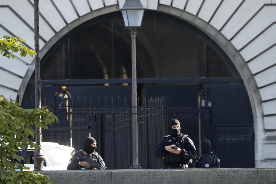 Security forces guard an entrance of the Palace of Justice Wednesday, Sept. 8, 2021 in Paris. France is putting on trial 20 men accused in the Islamic State group's 2015 attacks on Paris that left 130 people dead and hundreds injured. The proceedings begin Wednesday in an enormous custom-designed chamber. Most of the defendants face the maximum sentence of life in prison if convicted of complicity in the attacks. Only Abdeslam is charged with murder.